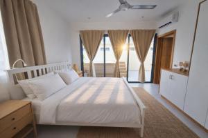 a bedroom with a white bed and a large window at Dream House Las Terrenas Terraza privada & Jacuzzi in Las Terrenas +15 photos