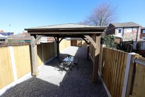 a gazebo with a table and a chair under it at Spacious 6-Guest Retreat with Pool Table in Dinnington