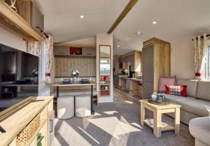 a living room with a couch and a kitchen at Solway Holiday Park in Silloth