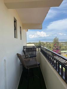 a balcony with two chairs and a view of the ocean at Fan Farm Stay in Munyu