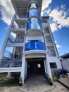 a large white building with a large window at Height 909 Hostal in Juayúa