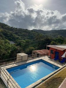 a large swimming pool in front of a house at Casa verde Recanto Doce lar in Gravatá