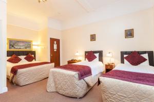 Habitación de hotel con 2 camas con almohadas rojas en Roseview Alexandra Palace Hotel, en Londres