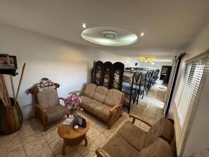 a living room with a couch and a table with skis at Height 909 Hostal in Juayúa