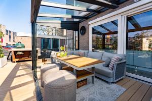 a patio with a table and chairs and glass doors at Hoek de luxe in Zoetermeer