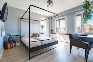 a bedroom with a four poster bed and a desk at Hoek de luxe in Zoetermeer