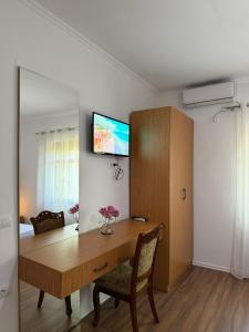 a room with a wooden table and a tv on the wall at Villa Fjorentin Berat in Berat