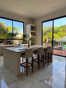 a kitchen with a table and chairs and large windows at Villa Paraiso in Holbox Island