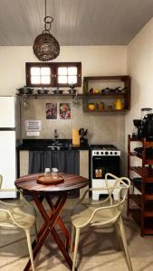 a kitchen with a table and chairs and a stove at Casa vermelha Recanto Doce Lar in Gravatá