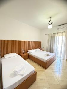 a bedroom with two beds and a window at Villa Fjorentin Berat in Berat