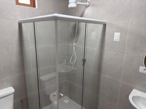 a shower with a glass door in a bathroom at Casa vermelha Recanto Doce Lar in Gravatá