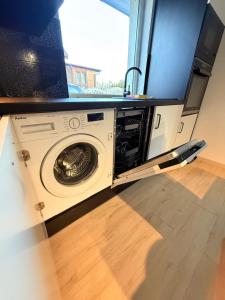 a washing machine in a room with a tv at Zakątek Lechicki Domek in Tarnów Jezierny