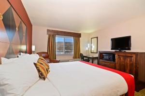 a hotel room with a bed and a flat screen tv at Inn America - Lewiston in Lewiston