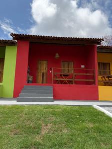 a red and yellow house with a red roof at Casa vermelha Recanto Doce Lar in Gravatá +4 photos
