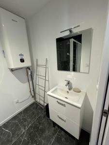 a white bathroom with a sink and a mirror at Jacuzzi et cinéma privatif P1 in Pessac