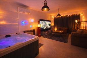 a living room with a jacuzzi tub in front of a tv at Jacuzzi et cinéma privatif P1 in Pessac