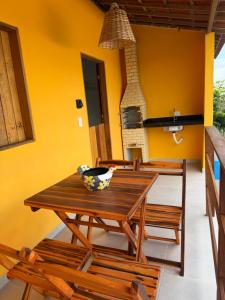 a dining room with a wooden table and chairs at Casa amarela Recanto Doce Lar in Gravatá +6 photos