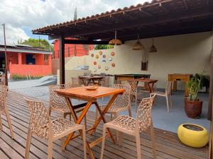 a wooden table and chairs on a wooden deck at Casa amarela Recanto Doce Lar in Gravatá