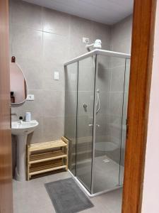 a shower stall in a bathroom with a sink at Casa amarela Recanto Doce Lar in Gravatá