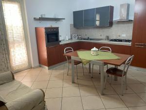 a kitchen with a table and chairs in a room at Manilù House in San Prisco