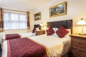 una camera d'albergo con due letti e una finestra di Roseview Alexandra Palace Hotel a Londra
