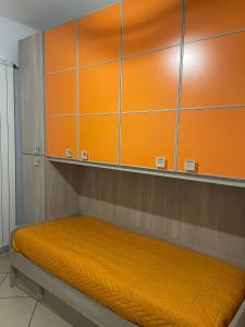 a bed in a room with an orange wall at Manilù House in San Prisco