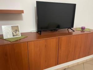 a flat screen tv sitting on top of a wooden cabinet at Manilù House in San Prisco