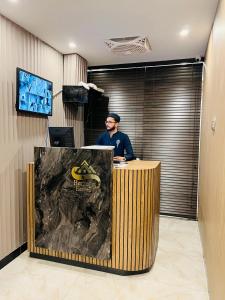 a man sitting at a desk in an office at Heritage Heaven by Premium Suites in Karachi