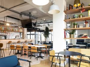 a restaurant with tables and chairs and a bar at ibis Styles Paris Romainville in Romainville