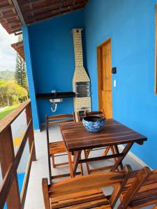 a wooden table and chairs on a balcony with a fireplace at Casa azul Recanto Doce Lar in Gravatá +6 photos