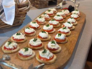 a tray of mini pizzas with cheese and greens on them at The Boardwalk Hotel in Saint Ignace