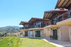 a large building with tables and chairs in front of it at Hilltop Chalet 2 in Hanioti
