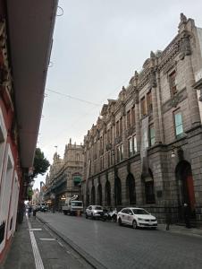 a city street with cars parked in front of buildings at Departamento 4 Ote in Puebla