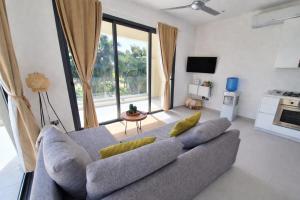 a living room with a couch and a large window at Dream House Las Terrenas Terraza privada & Jacuzzi in Las Terrenas