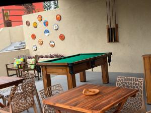 a ping pong table in a room with a wall with plates at Casa Laranja Recanto Doce Lar in Gravatá