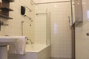 a bathroom with a sink and a shower with a sink at Iconic 3-BR Home Steps from Duomo in Milan