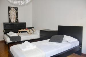 a bedroom with two beds and a table in it at Iconic 3-BR Home Steps from Duomo in Milan