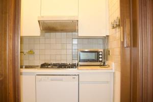 a small kitchen with a microwave and a stove at Iconic 3-BR Home Steps from Duomo in Milan