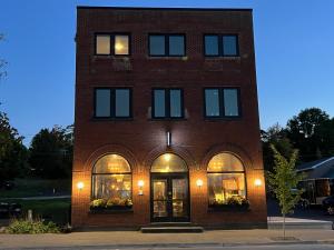a red brick building with windows and doors at The Boardwalk Hotel in Saint Ignace