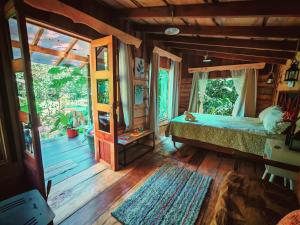 a bedroom with a bed in a wooden house at DondeLalo Hospedaje y Camping in Heredia