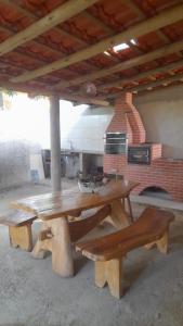 a picnic table and benches in a kitchen with a stove at Barbosa in Três Marias