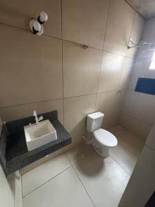 a bathroom with a white toilet and a sink at Barbosa in Três Marias +18 photos