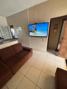 a living room with a couch and a flat screen tv at Barbosa in Três Marias