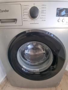 a front loading washing machine with its door open at Appartement de luxe in Sidi Daoud