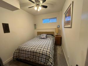 a bedroom with a bed and a ceiling fan at Calgary Lake House B&B in Calgary