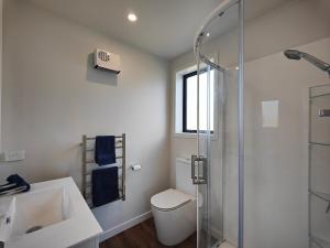 a bathroom with a shower and a toilet and a sink at Rack n Relax Riverton in Riverton +22 photos