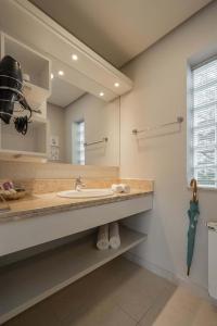 a bathroom with a sink and a large mirror at Doce Canela - Pousada de Charme in Canela