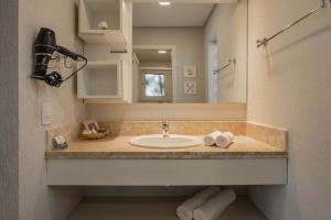 a bathroom with a sink and a mirror at Doce Canela - Pousada de Charme in Canela