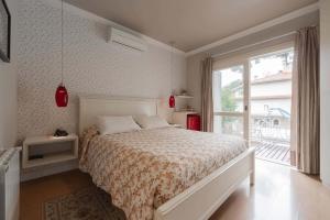 a bedroom with a bed and a large window at Doce Canela - Pousada de Charme in Canela +156 photos