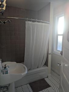 a bathroom with a tub and a sink and a shower at Charles Street Vacation Home in Lethbridge +29 photos